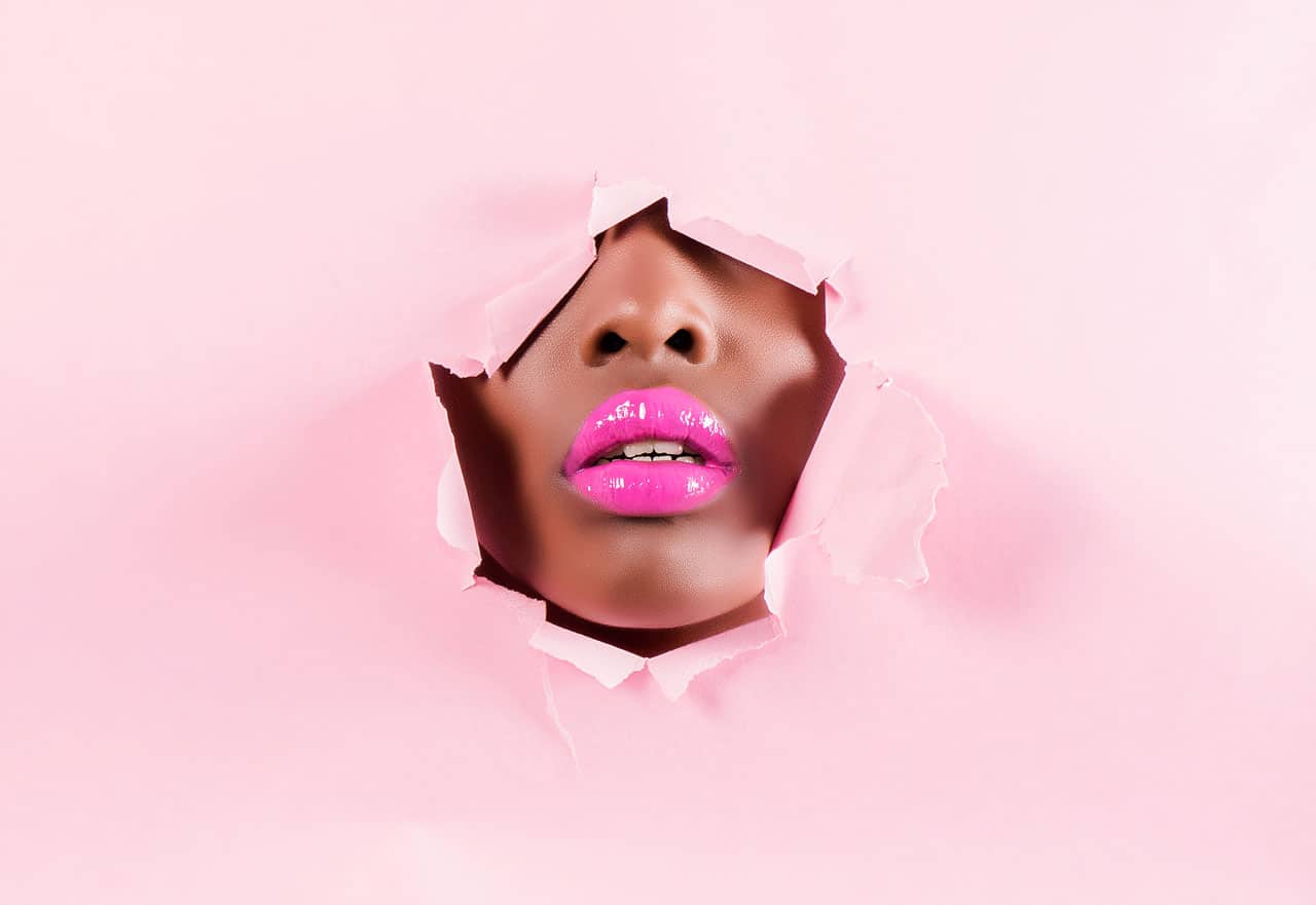 Pinke Lippen kommen durch Wandöffnung